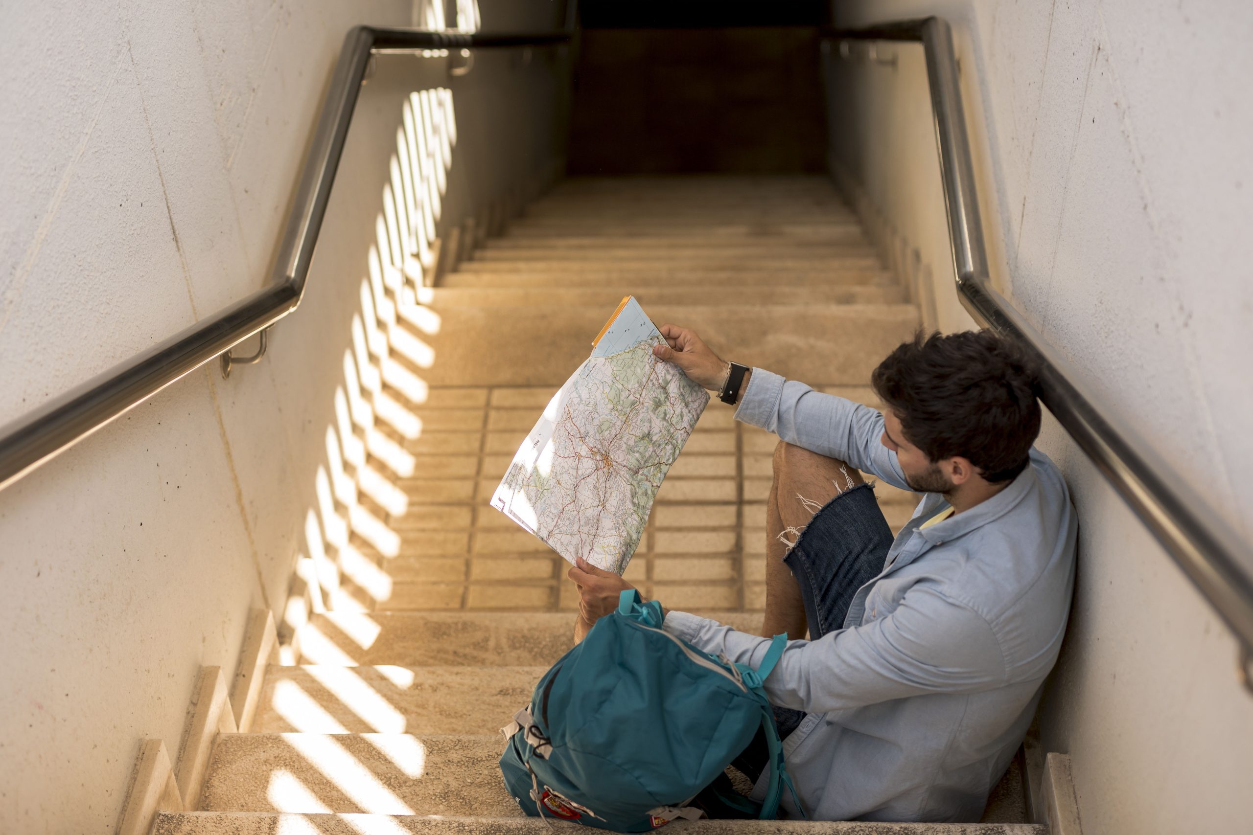 traveler-sitting-stairs-looking-map