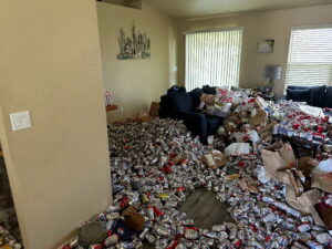 living room of hoarder house garbage and soda cans and trash